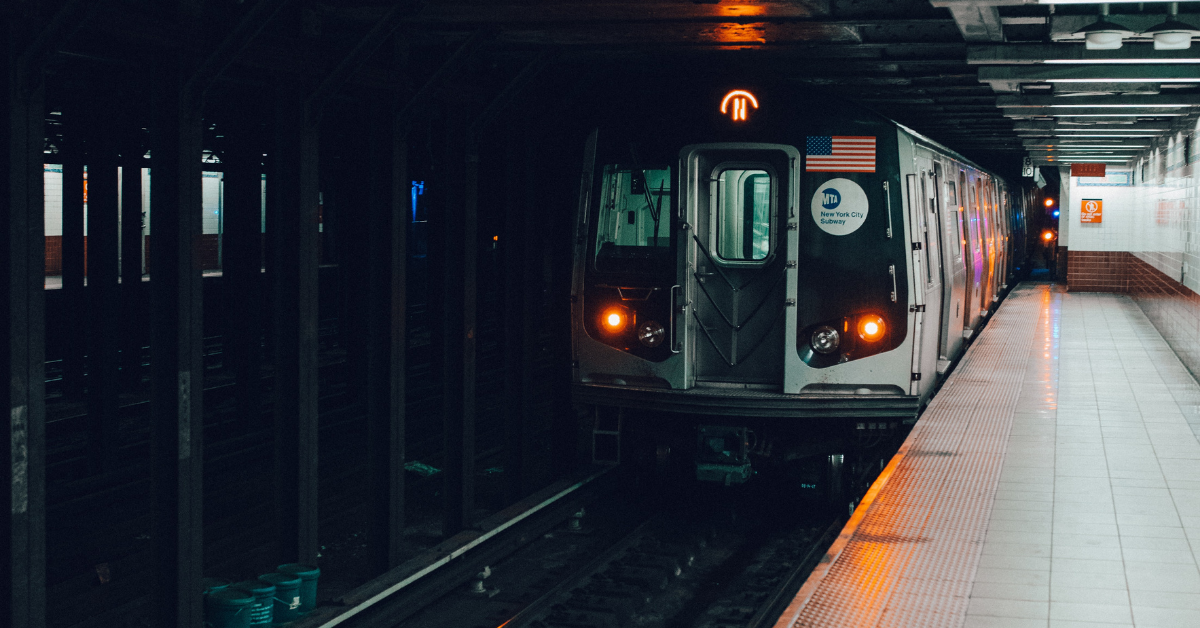 Chauffeur vs driver as a  subway train chugging past in a dark, underground tunnel